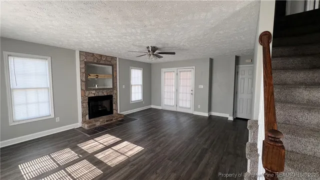 an empty room with windows and a fireplace