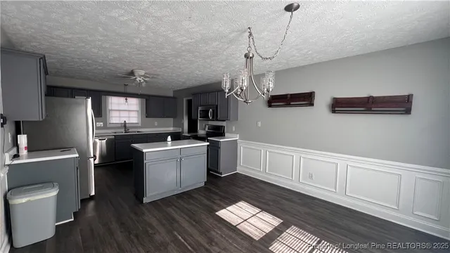 a kitchen with cabinets wooden floor and stainless steel appliances