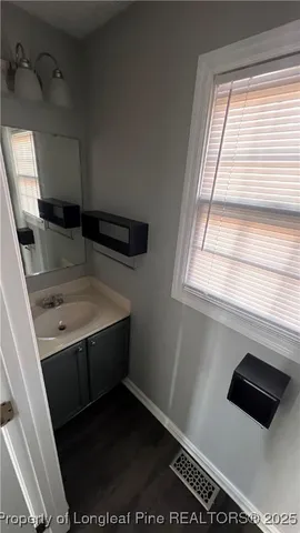 a bathroom with a sink a toilet and a window