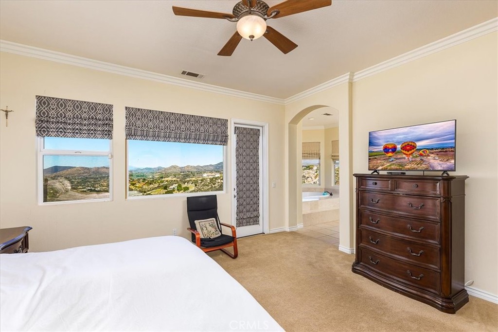 39110 Loren Way Temecula, CA 92592 - Photo 12 of 42 a bedroom with a bed and a chandelier