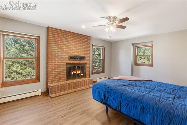 356 Spring Valley Drive Divide, CO 80814 - Photo 23 of 50 Upper level bedroom with woodburning fireplace, LVP flooring and ensuite