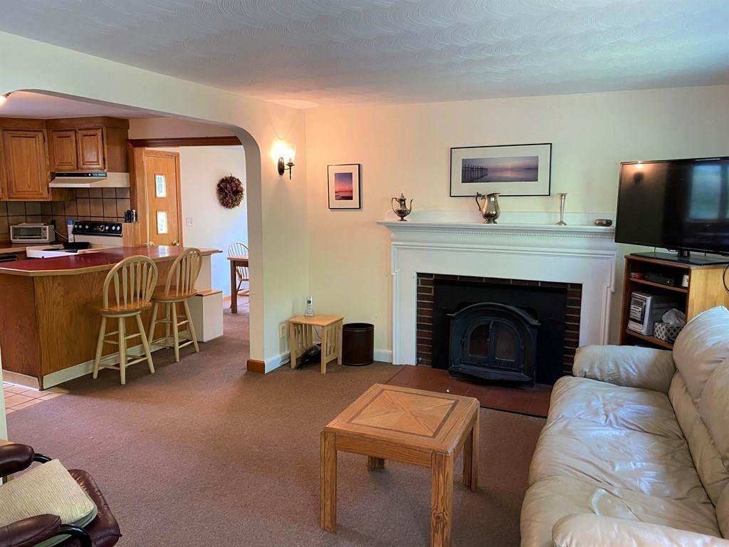 25 Clearwater Road Newton, MA 02462 - Photo 5 of 23 a living room with furniture a flat screen tv and a fireplace