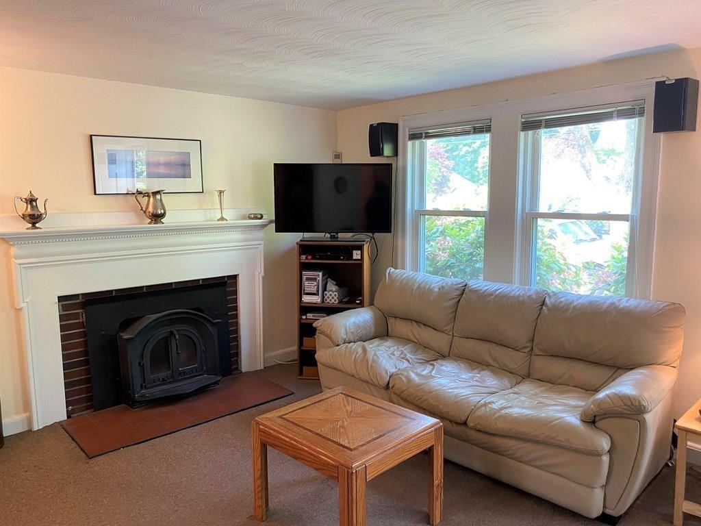 25 Clearwater Road Newton, MA 02462 - Photo 6 of 23 a living room with furniture a flat screen tv and a fireplace