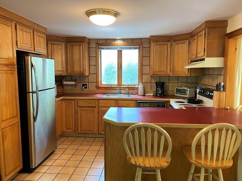 25 Clearwater Road Newton, MA 02462 - Photo 8 of 23 a kitchen with stainless steel appliances granite countertop a stove a sink and a refrigerator