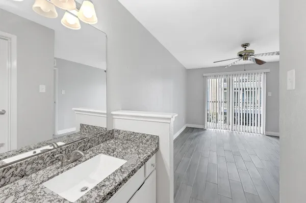 a bathroom with a granite countertop sink and a mirror
