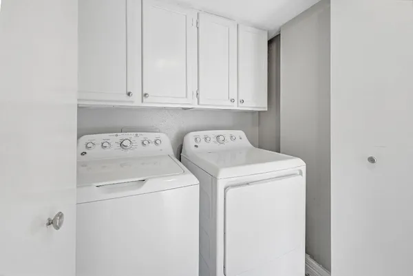 an empty room with wooden floor chandelier fan and windows
