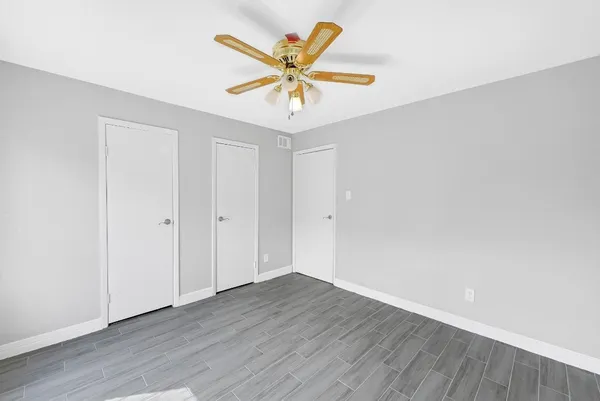 a bathroom with a granite countertop sink a toilet a mirror and shower