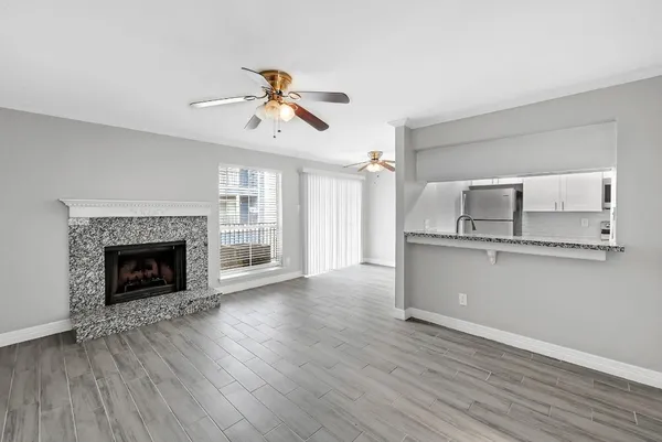 an empty room with windows and fireplace