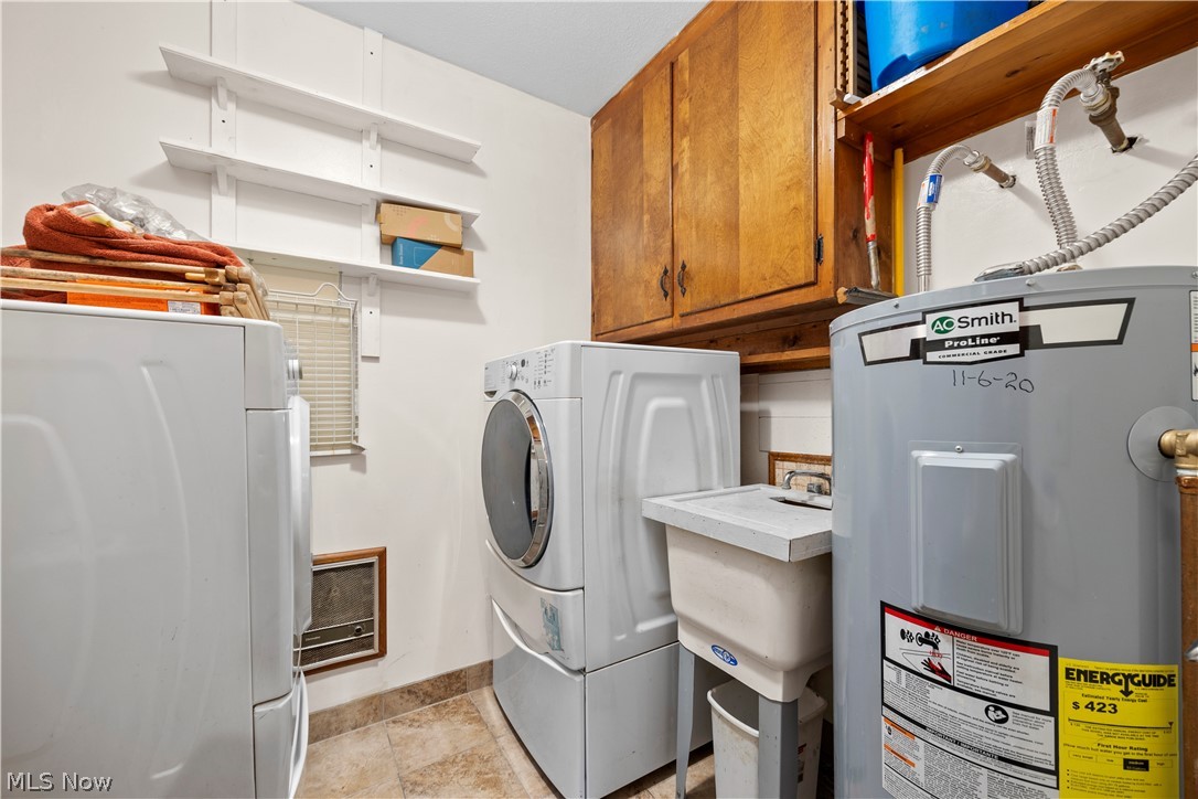 11923 Green Road Wakeman, OH 44889 - Photo 24 of 45 Laundry area featuring electric water heater, cabinet space, and independent washer and dryer