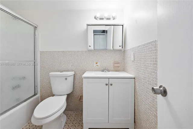 a white toilet sitting next to a bathroom sink