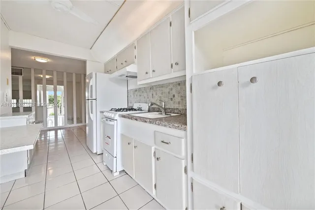 a large white kitchen with cabinets
