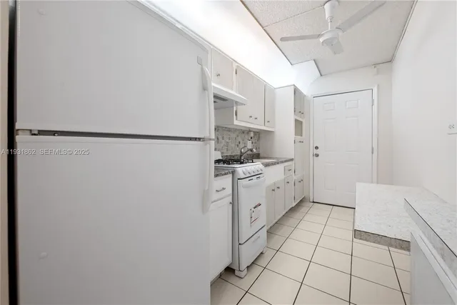 a kitchen with white cabinets and white appliances