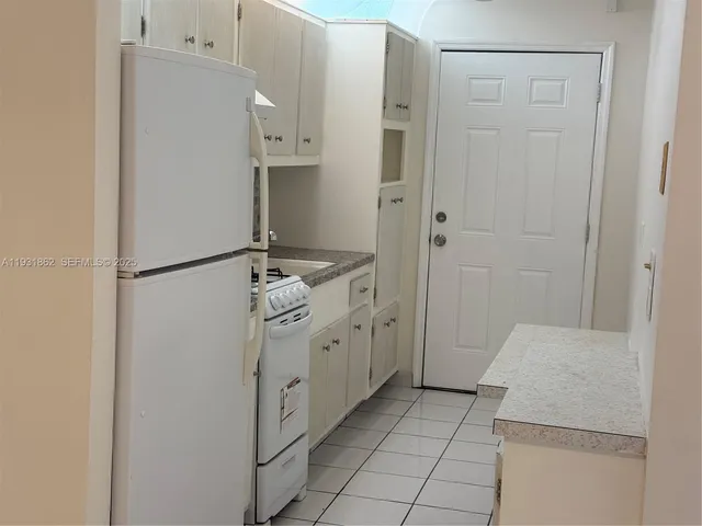 a room with white cabinets and sink