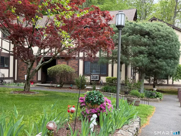 a front view of a house with a yard and tree s
