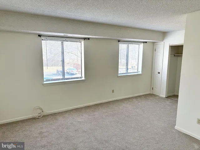 an empty room with windows and closet