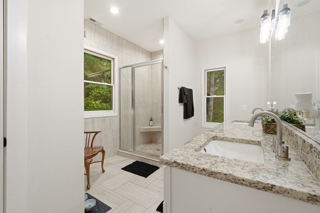 175 Crane Creek Road Young Harris, GA 30582 - Photo 22 of 40 a bathroom with a granite countertop sink and a mirror