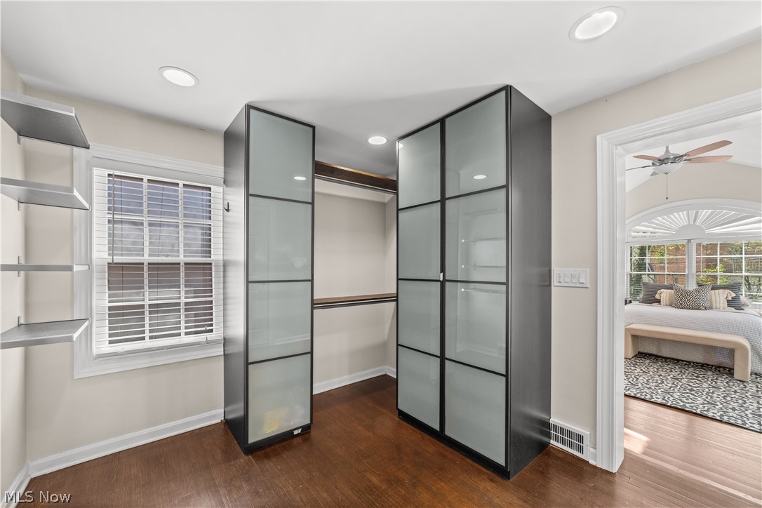 3806 Westwood Road University Heights, OH 44118 - Photo 17 of 41 Custom closet system featuring frosted glass panels and dark framing, recessed lighting, wood-finish flooring, built-in shelving, and a multi-pane window