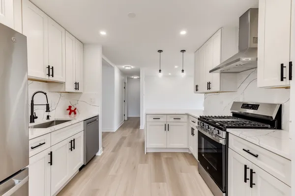 a kitchen with stainless steel appliances granite countertop a sink stove and cabinets