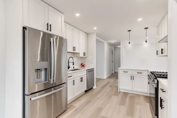 a kitchen with white cabinets and stainless steel appliances