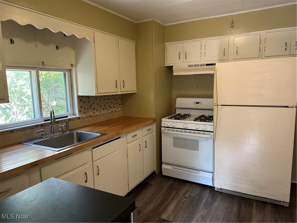 1596 Wood Road Cleveland Heights, OH 44121 - Photo 16 of 25 Kitchen with refrigerator, range, dark wood-style flooring, white cabinets, and ornamental molding