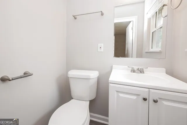 a bathroom with a toilet sink and mirror