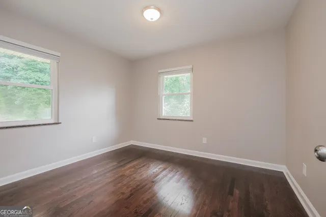 a view of a room with wooden floor and windows