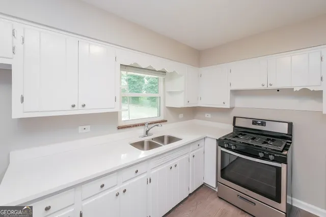 a kitchen with white cabinets and appliances