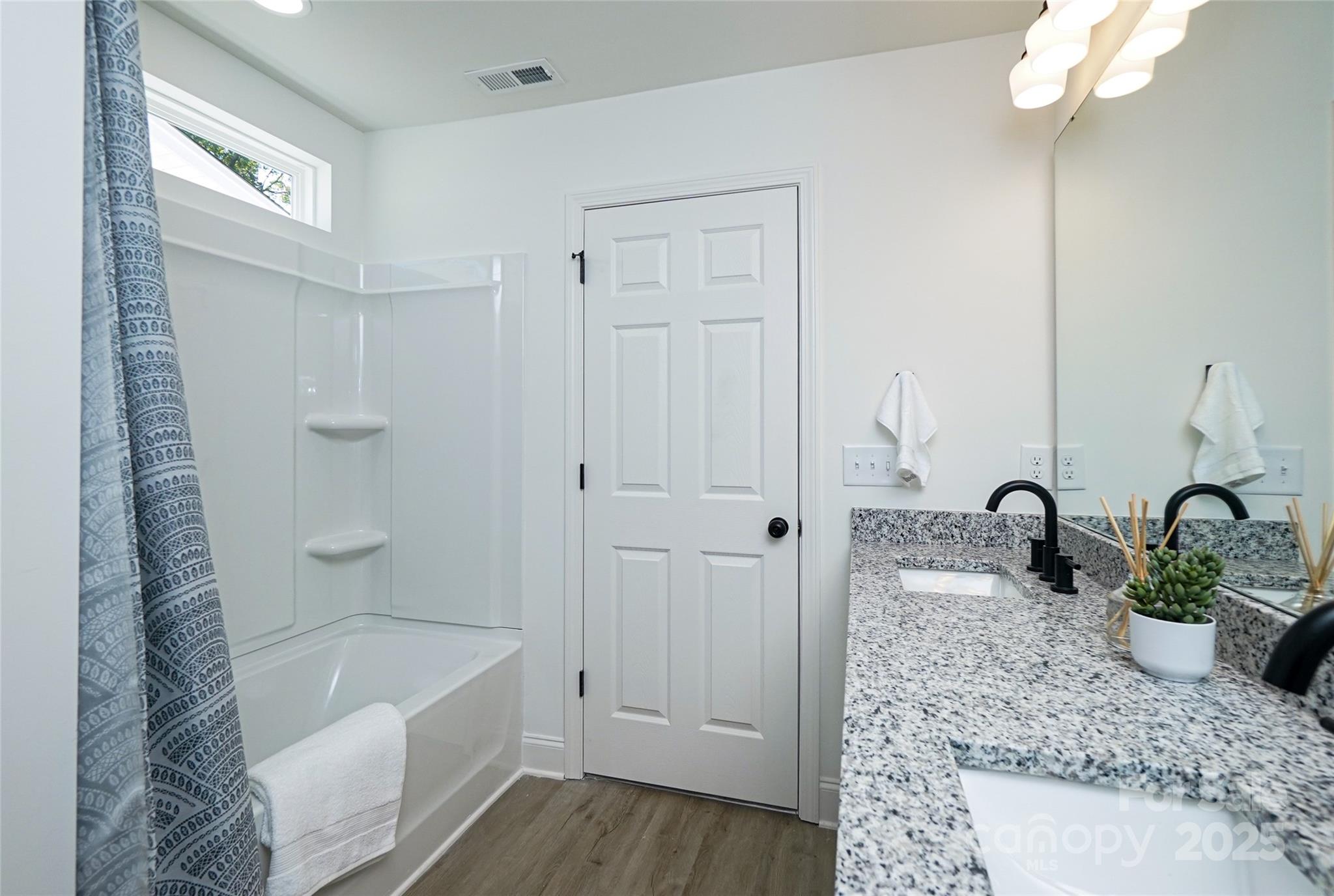 3224 Sam Wilson Road Charlotte, NC 28214 - Photo 22 of 32 a bathroom with a granite countertop sink a bathtub and shower