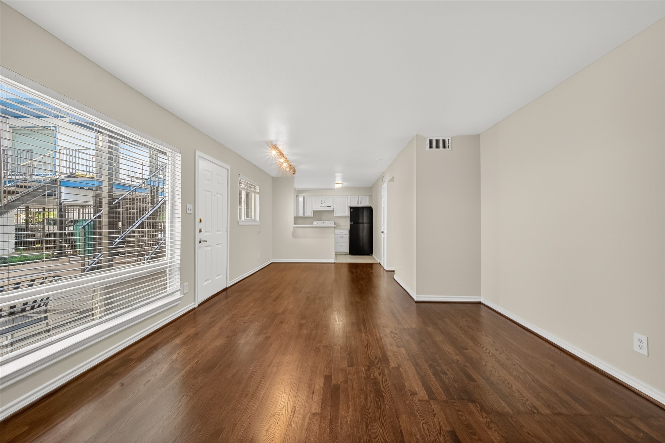 2020 Huldy Street, Unit 1 Houston, TX 77019 - Photo 11 of 30 a view of an empty room with wooden floor and a window