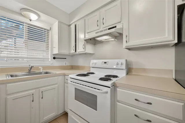 a kitchen with cabinets and steel appliances