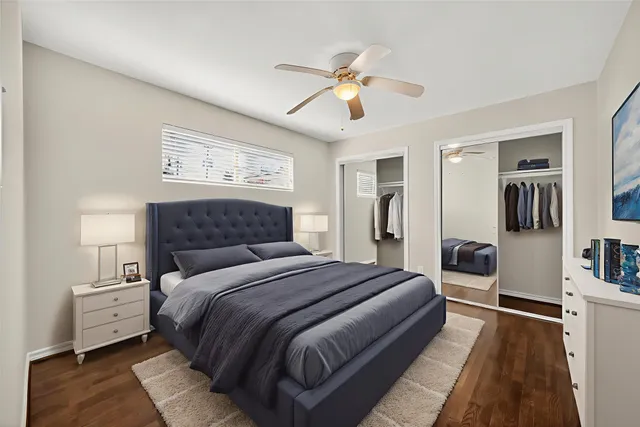 an empty room with wooden floor and ceiling fan