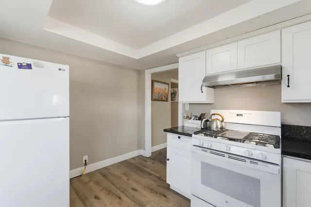 a view of kitchen with refrigerator and wooden floor