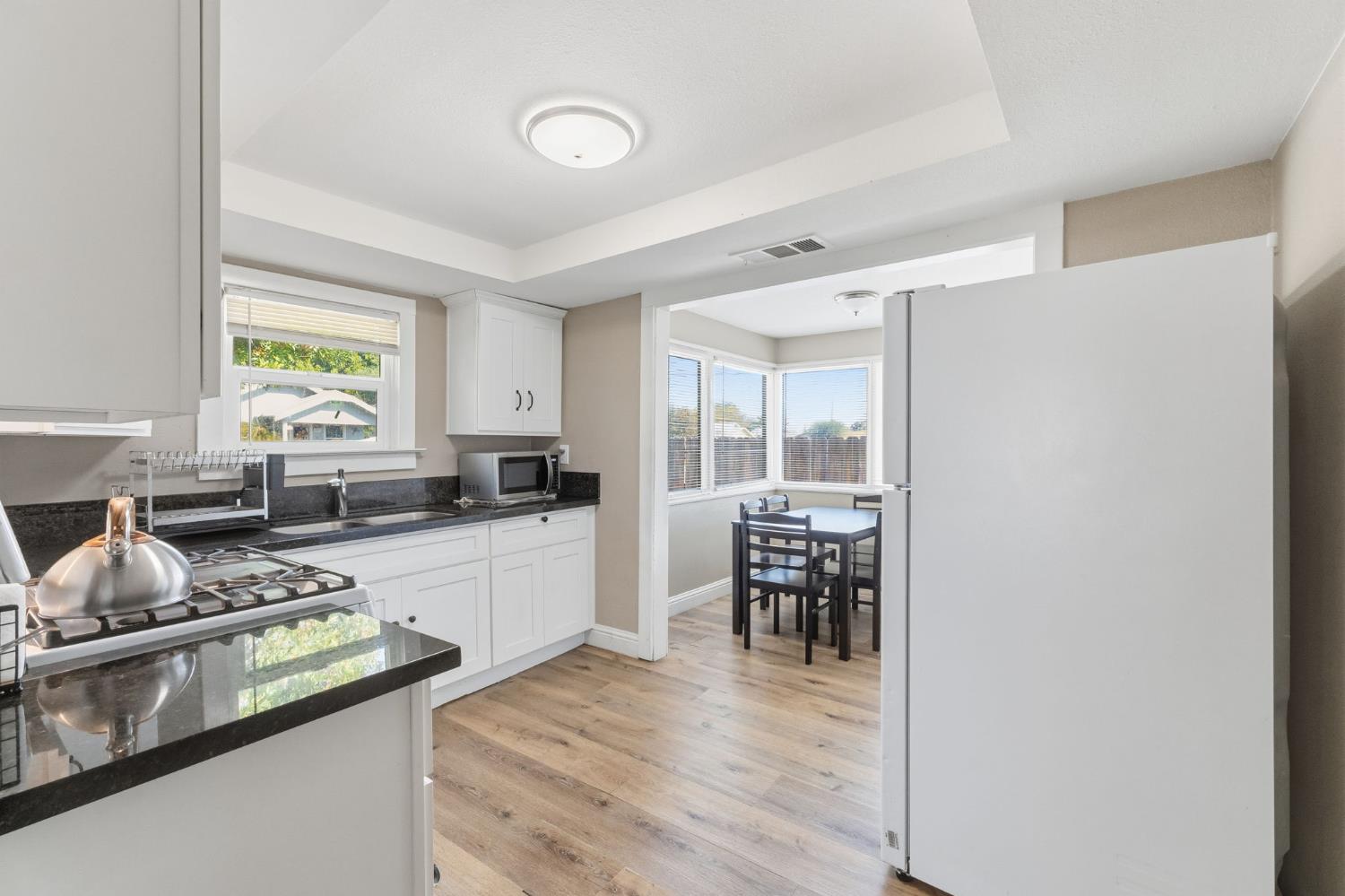 321 North Orange Avenue Exeter, CA 93221 - Photo 10 of 37 a kitchen with a table chairs stove and cabinets