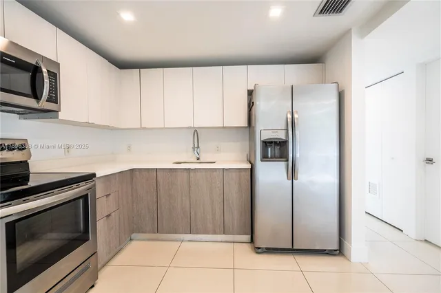 a kitchen with stainless steel appliances granite countertop a refrigerator and a stove top oven