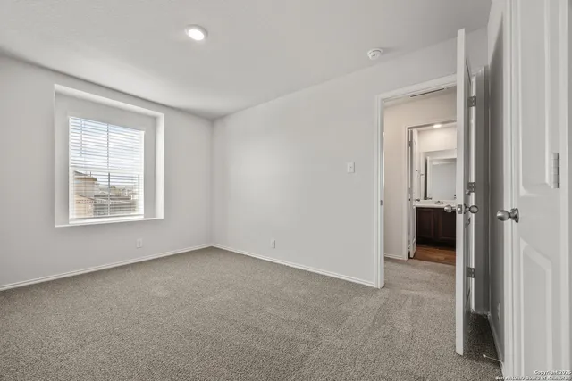 an empty room that has a window and a bathroom