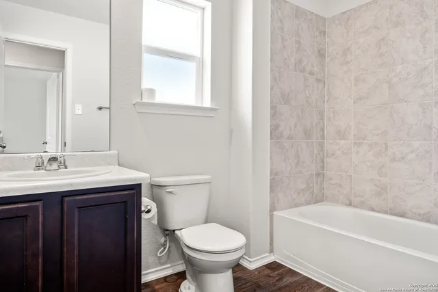 a bathroom with a granite countertop toilet a sink and a bathtub