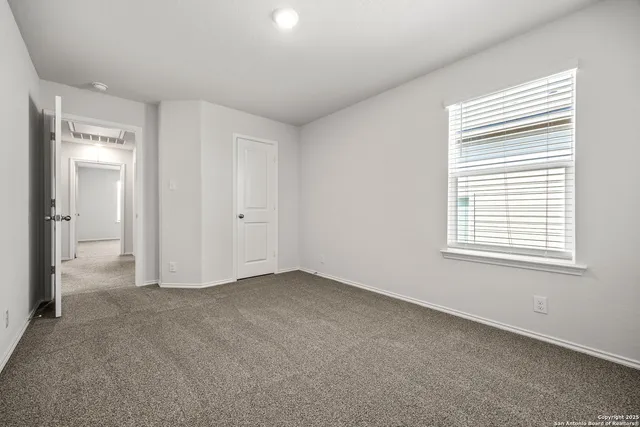 an empty room with a window and a bathroom