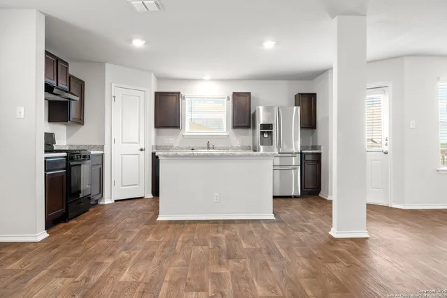 a kitchen with a refrigerator and a stove top oven