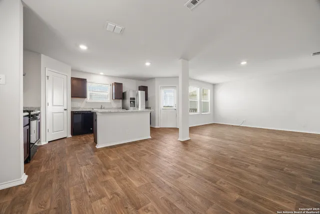 a view of a kitchen with a sink stove cabinets and empty room