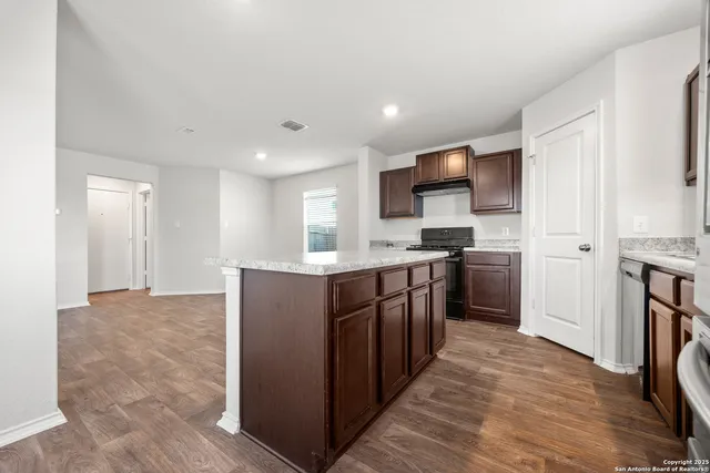 a kitchen with stainless steel appliances granite countertop a refrigerator and a stove top oven