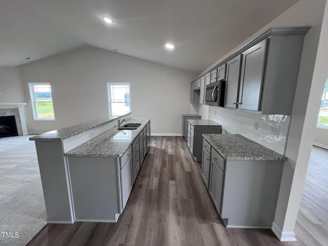 a kitchen with granite countertop a sink and wooden floor
