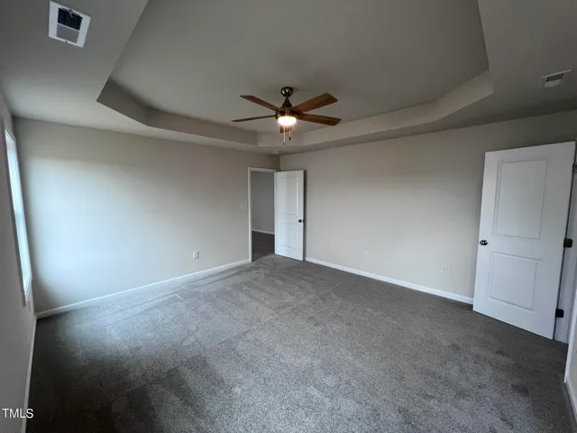 an empty room with a ceiling fan and a window