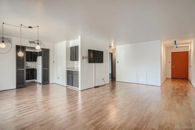 a view of a livingroom with wooden floor and a fireplace
