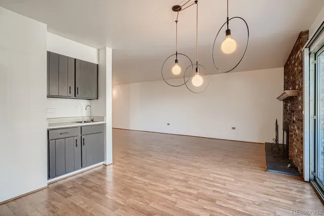 a view of a room with wooden floor and kitchen view