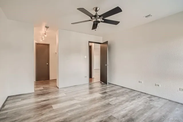 an empty room with wooden floor and windows