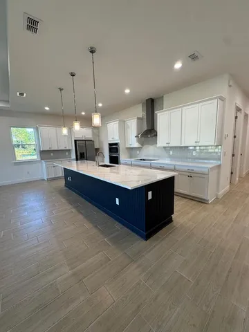a large kitchen with kitchen island a island a stove a sink a center island and cabinets