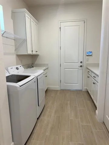 a utility room with cabinets washer and dryer