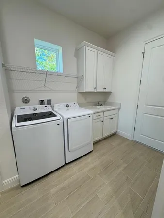 a utility room with sink dryer and washer