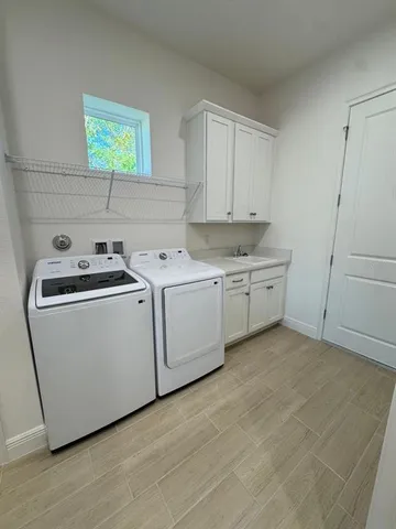 a utility room with sink dryer and washer