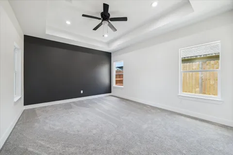 en empty room with windows and ceiling fan